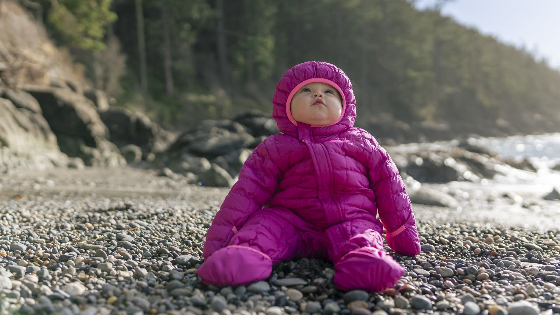 baby in jacket on the beach